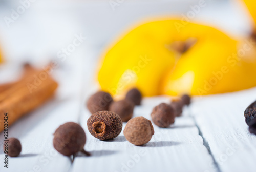 allspice and cinnamon rolls, quince jelly dessert ingredients on white wood table