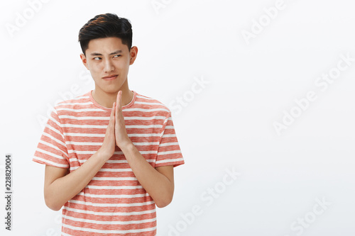 Fotografija Guy having mysterious and evil intention, bethinking plan of revenge, rubbing palm over chest squinting, staring at upper right corner thoughtful