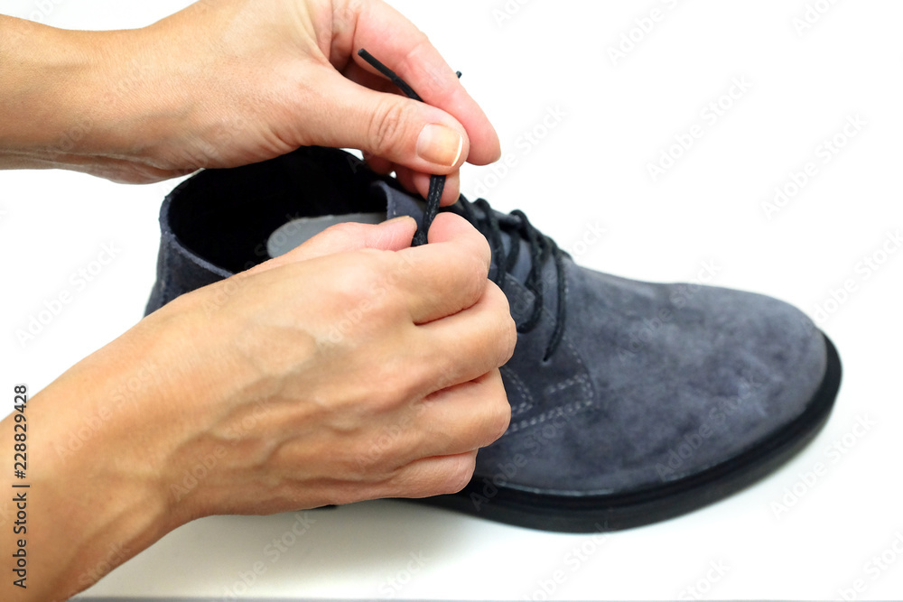 Girl tying shoelaces on shoes. Top view close-up