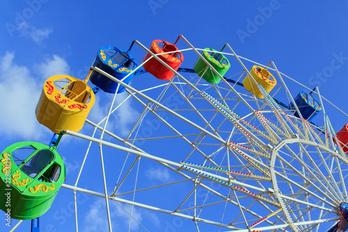 Underside view of a ferris wheel over blue sky
