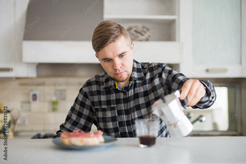 Young man smiling and holding a cup of coffee in kitchen Young man smiling and holding a cup of coffee in kitchen