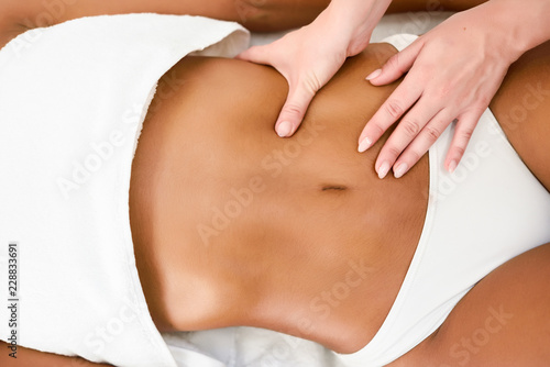 Woman receiving abdomen massage in spa wellness center. photo