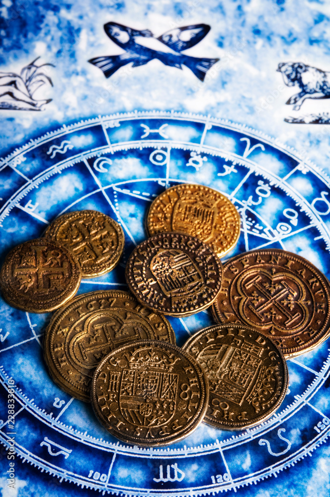 money gold coins lying on horoscope with zodiac signs like a concept astrology and wealth, abundance