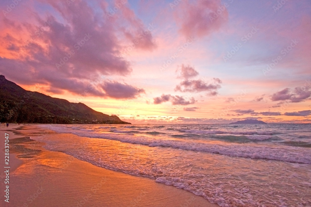 Fototapeta premium Sunset over a beautiful beach in Mahe, Seychelles.