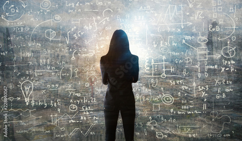 Young woman looking on the black board with mathematical formulas and calculations. Bright idea, way of thinking, discovery and challenge concept.  photo
