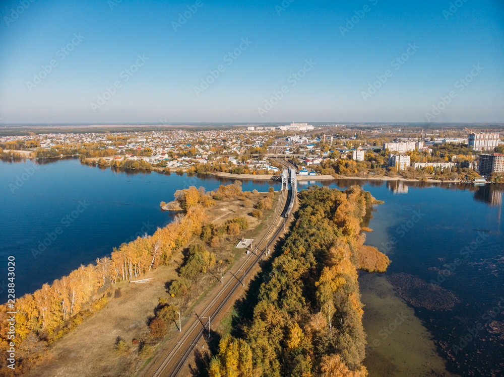 Aerial panoramic view of cityscape with river in sunny day, autumn city landscape from above