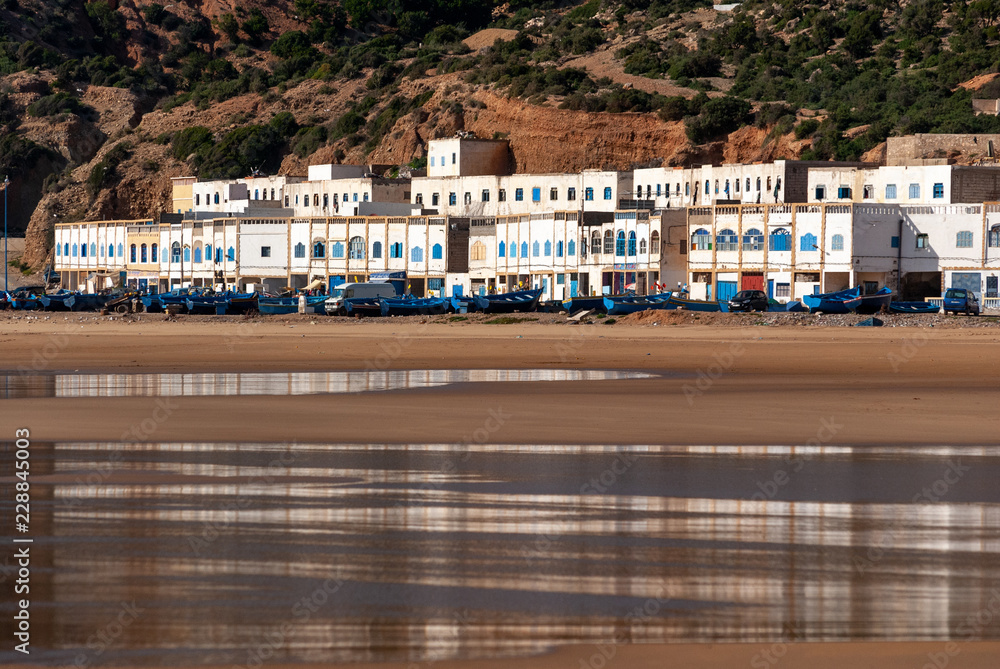 The village of Tafelney, near Essaouira in Morocco, is reflected on the wet sand of the beach at low tide