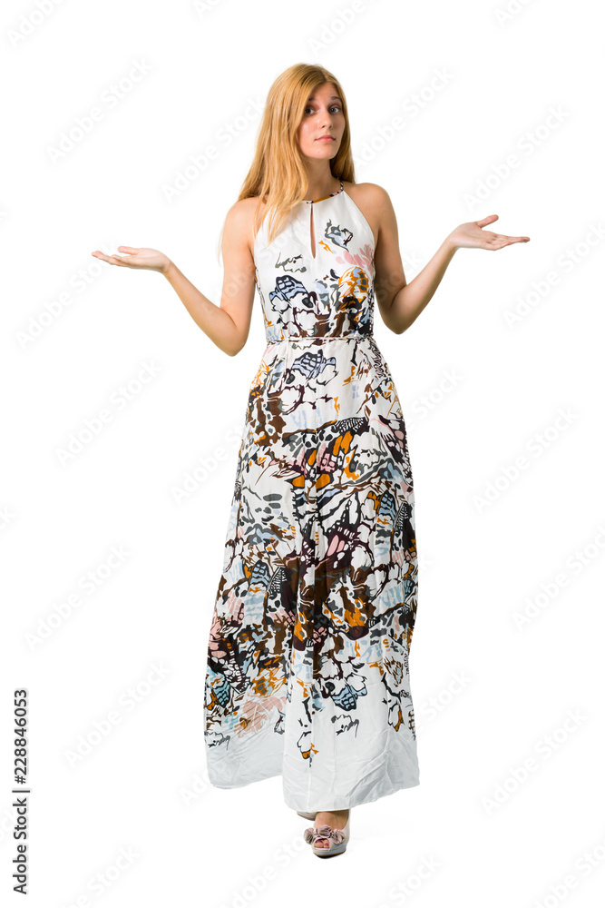 Blonde young girl in a summer dress having doubts and with confuse face expression while raising hands and shoulders on isolated white backgroun Blonde young girl in a summer dress having doubts and with confuse face expression while raising hands and shoulders on isolated white backgroun