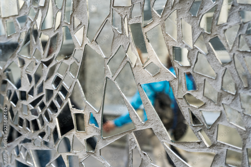 Shards of a mirror glass pattern on a wall.
