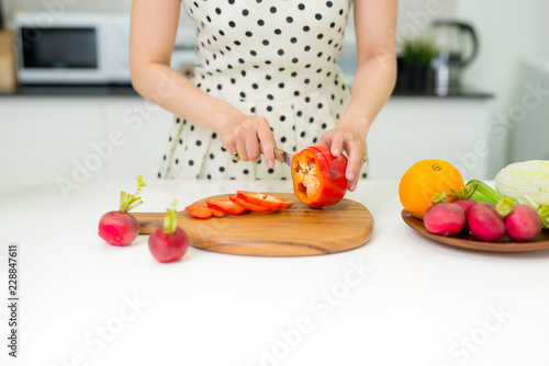 Happy cooking. Young asian woman cutting vegetables for salad in the kitchen