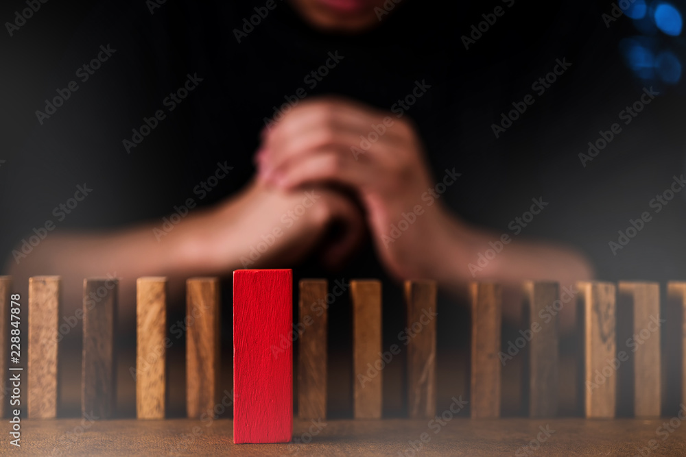 business man try to choose red color wood block from others on wooden table and black background business organization startup concept
