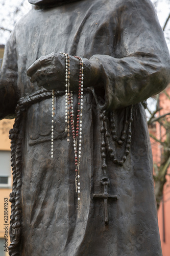 Bronze Statue of a Saint with Catholic Rosary Hanging Along the Arm
