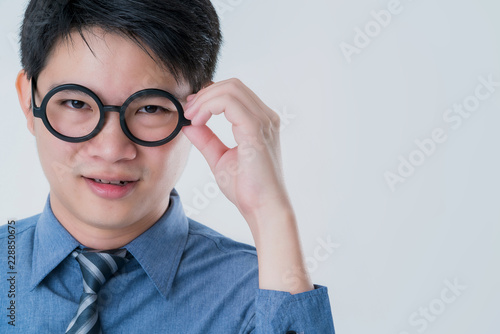 business asian male in blue shirt hand touch round black glasses focus and concentrate