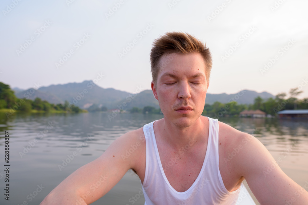 Tourist man sitting in boat while having holiday in Thailand