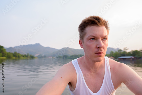 Tourist man sitting in boat while having holiday in Thailand