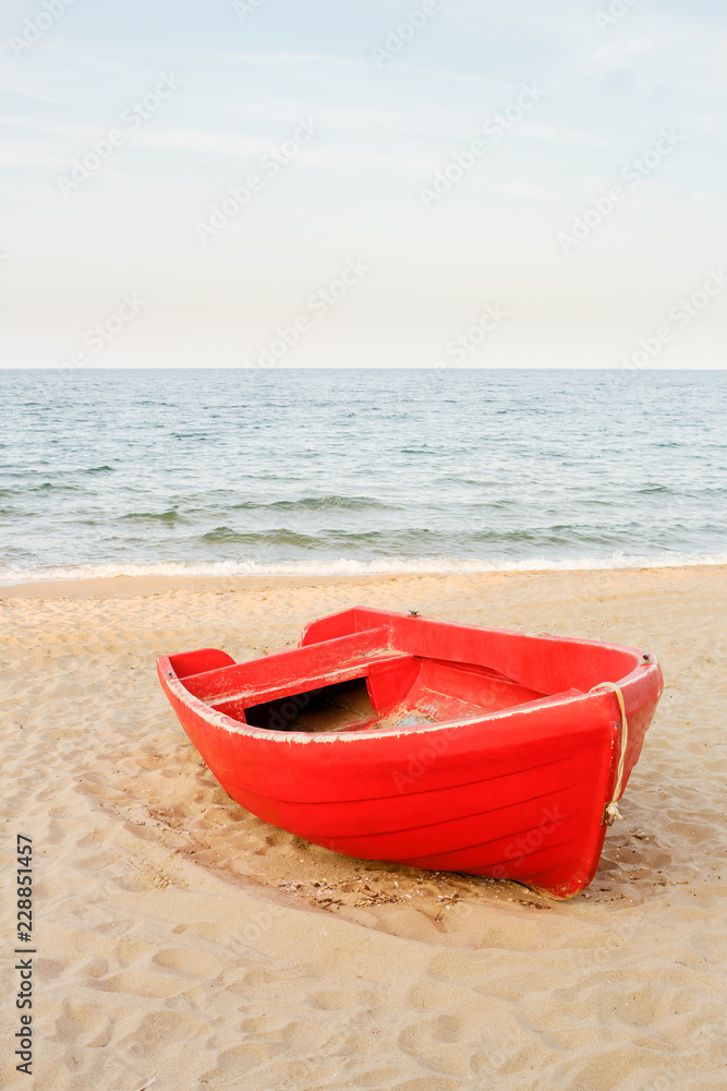 Old red boat on the beach, waves on the water and sky background Old red boat on the beach, waves on the water and sky background