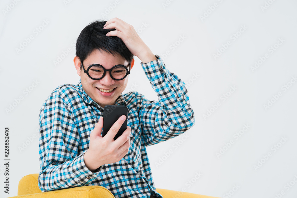busy asian man tshirt hand hold smartphone on sofa busy asian man tshirt hand hold smartphone on sofa