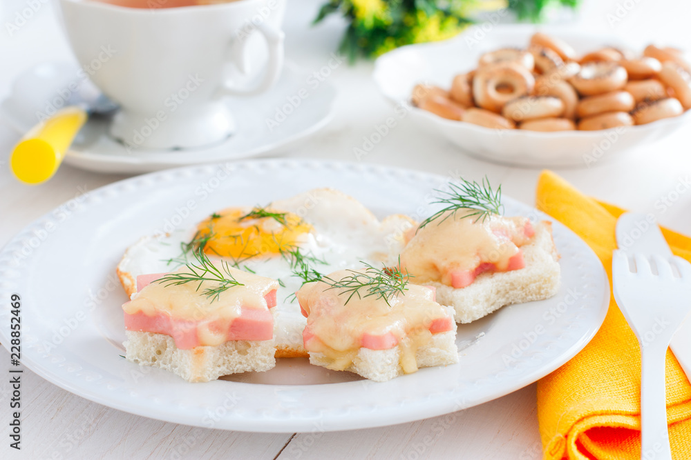 Breakfast with fried egg and hot sandwiches with sausage and cheese, horizontal Breakfast with fried egg and hot sandwiches with sausage and cheese, horizontal