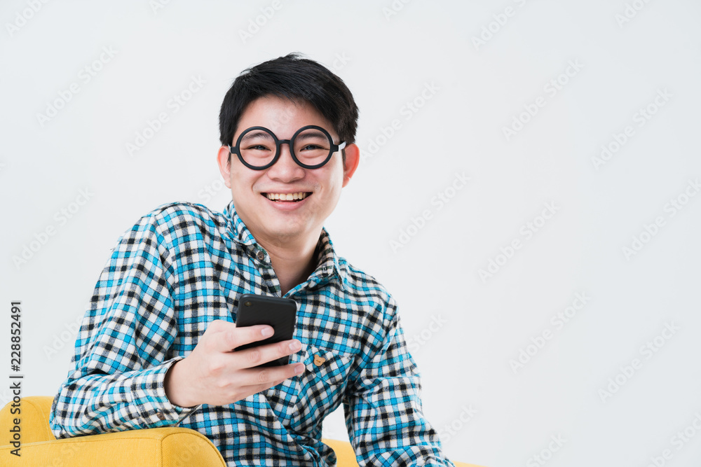busy asian man tshirt hand hold smartphone on sofa busy asian man tshirt hand hold smartphone on sofa