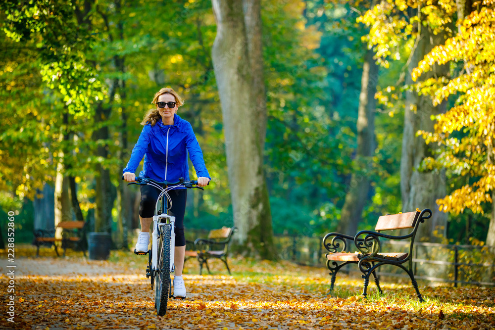 Urban biking - woman riding bike in city park Urban biking - woman riding bike in city park