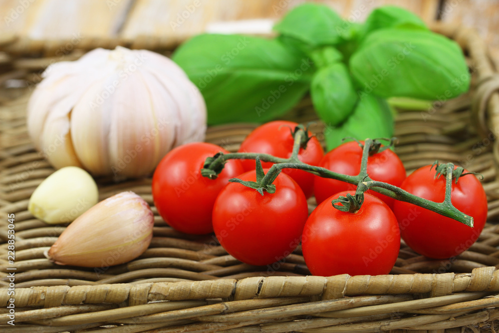 Selection of fresh organic ingredients for pasta: cherry tomatoes, garlic and basil on wicker tray
Selection of fresh organic ingredients for pasta: cherry tomatoes, garlic and basil on wicker tray