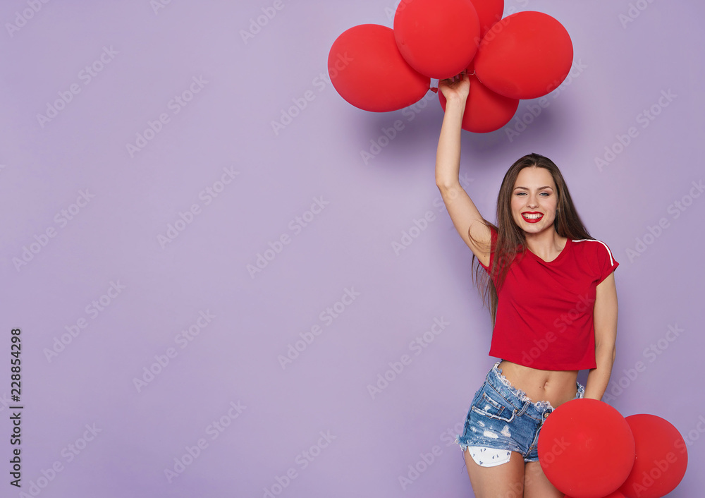 image of brunette woman with red balloons on violet background image of brunette woman with red balloons on violet background