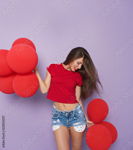 image of brunette woman with red balloons  on violet  background photo