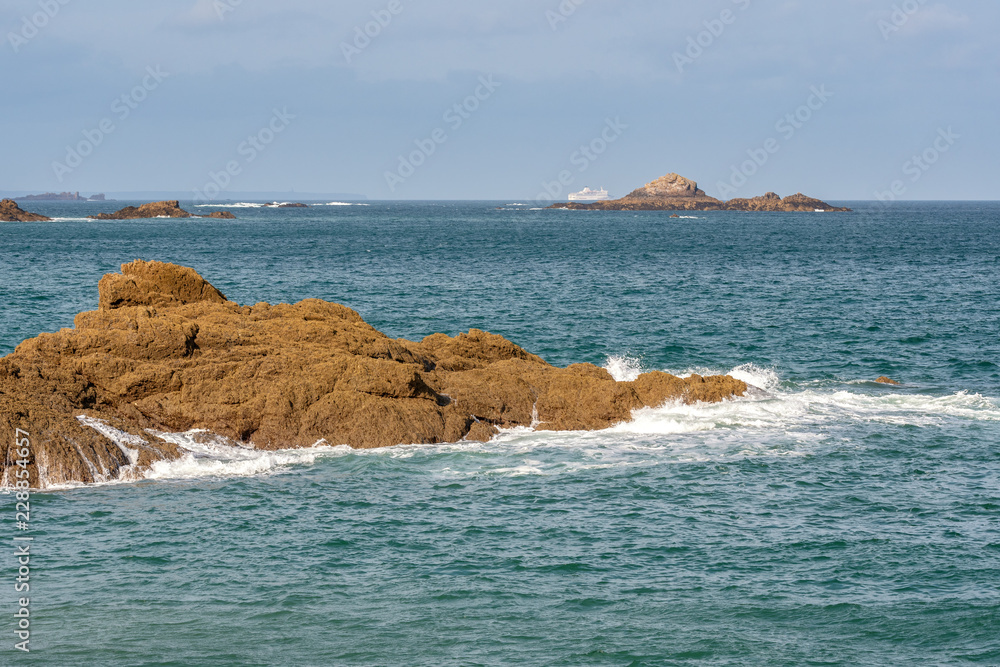 French landscape - Bretagne. Panorama of a beautiful rocky coast with ferry in the background.