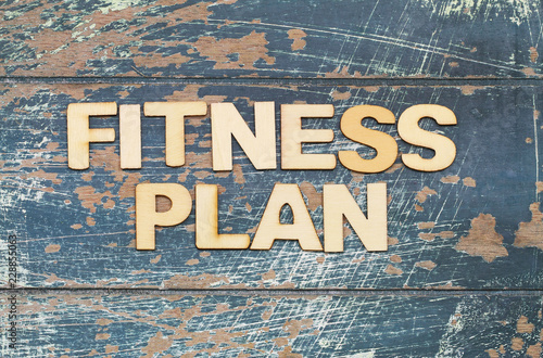 Fitness plan written with wooden letters on rustic wooden surface
 photo