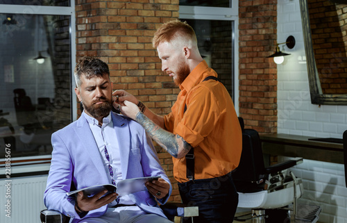 Man visiting hairstylist in barbershop. Hairdressers work for a handsome guy at the barber shop.