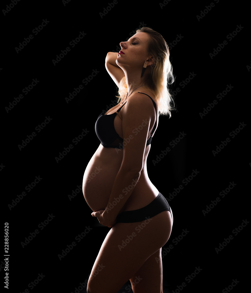Fototapeta premium Artistic silhouette of blonde pregnant woman on isolated background