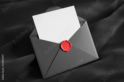 Open gray envelope on black tissue