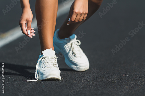 Woman runner tying shoelace on running track,Athlete to tie her shoes
