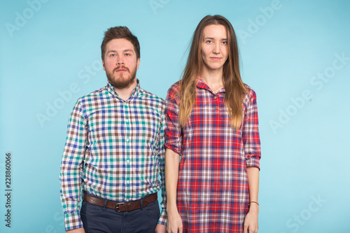 Portrait of cheerful funny young lovers fooling around on blue background