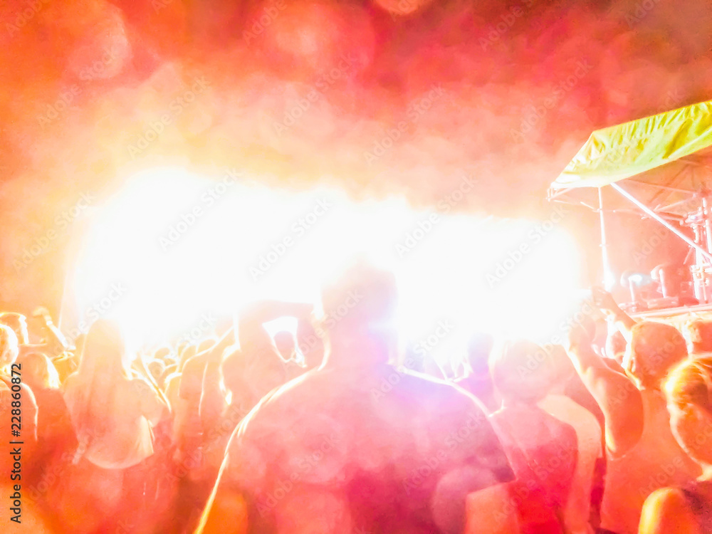 The party, concert concept. Crowd raising their hands and enjoying great rock festival. blur bokeh for background.