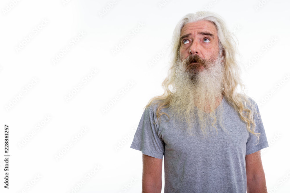 Studio shot of senior bearded man thinking while looking up Studio shot of senior bearded man thinking while looking up