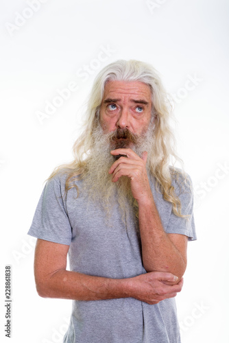 Studio shot of senior bearded man thinking while looking up 