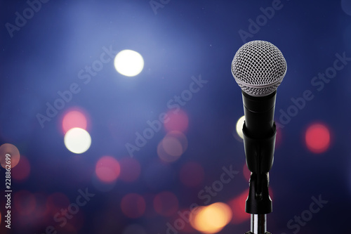 Microphone on stage ..Close up of microphone setting on stand with colorful light bokeh background in conference hall .