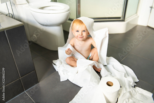 Tableau sur toile Toddler ripping up toilet paper in bathroom