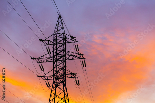 Silhouettes of power lines on a sunset. Bright orange urban sunset
