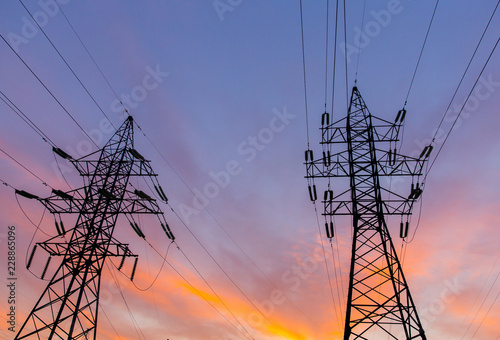 Silhouettes of power lines on a sunset. Bright orange urban sunset