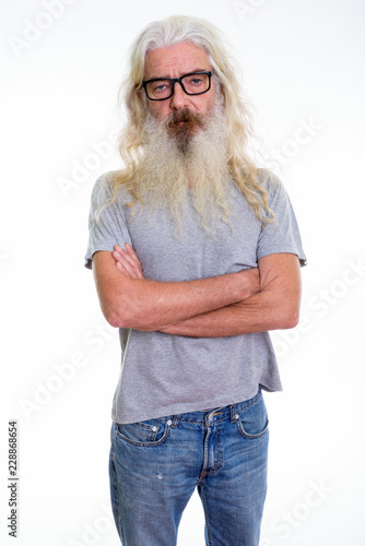 Studio shot of senior bearded man standing while wearing eyeglas photo