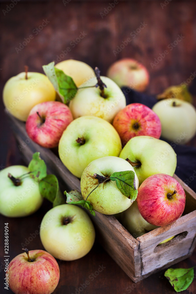 Fresh ripe colorful apples in wooden box on rustic background Fresh ripe colorful apples in wooden box on rustic background