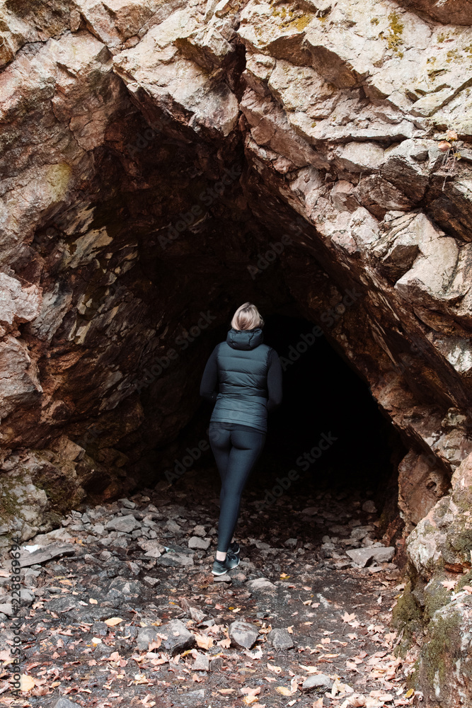 Girl exploring a dark cave in the mountains. Bode Gorge (Bodetal), National Park Harz Mountains, Thale,  Saxony-Anhalt in Germany