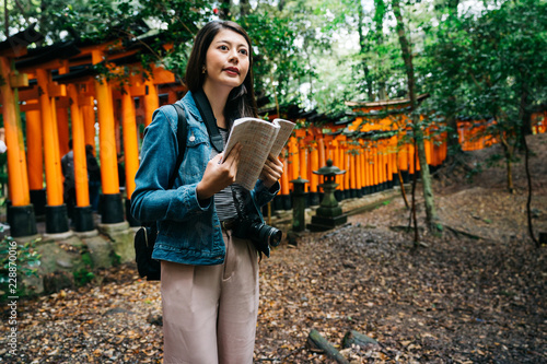Εκτύπωση καμβά elegant asian photographer holding her guidebook