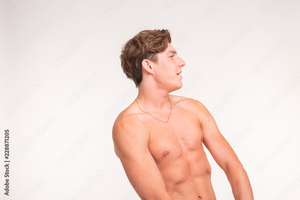 People, gesture and sport concept - young confident shirtless man showing fists on white background with copy space