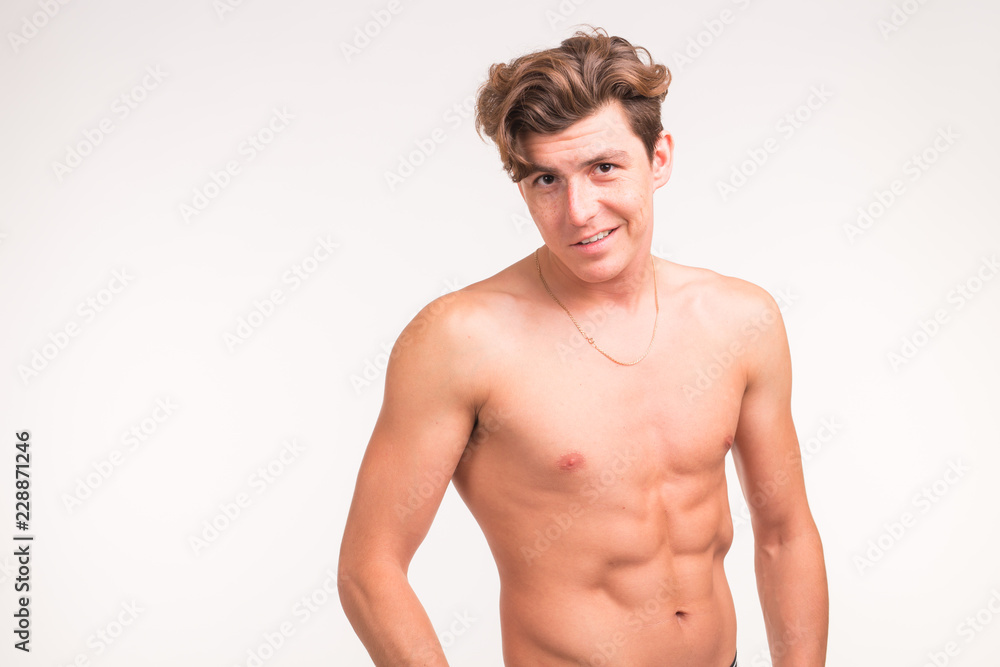 People, gesture and sport concept - young confident shirtless man showing fists on white background with copy space