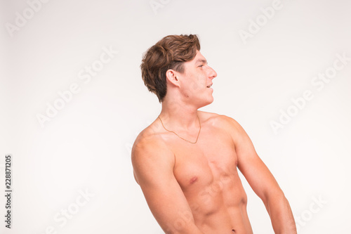 People, gesture and sport concept - young confident shirtless man showing fists on white background with copy space