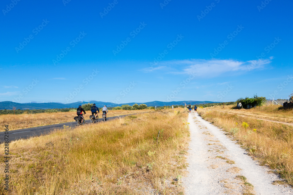 Obraz premium Camino de Santiago (Spain) - Pilgrims and bikers along the way of St.James, in the spanish meseta