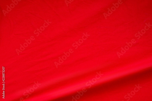 Red fabric background. Elegant vivid silk wave material texture.